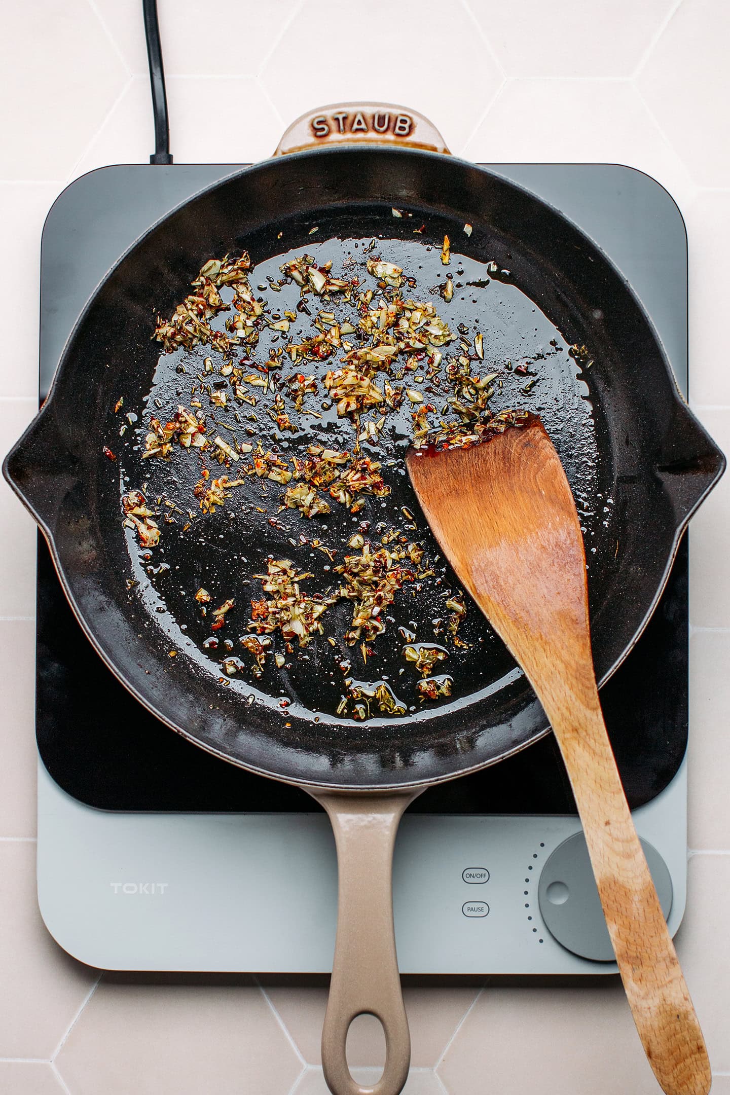 Sautéed garlic, dried herbs, and red pepper flakes in a skillet.