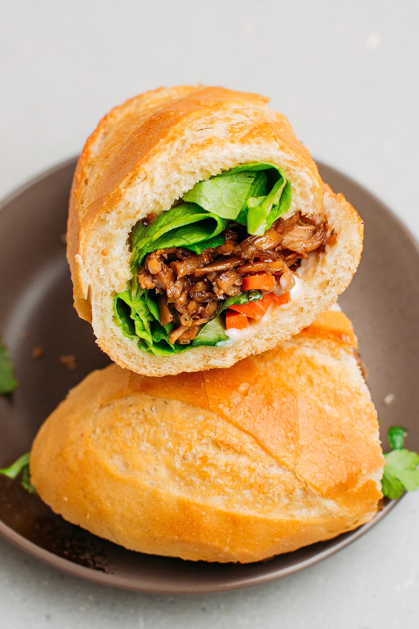 Two halves of banh mi on a small plate.