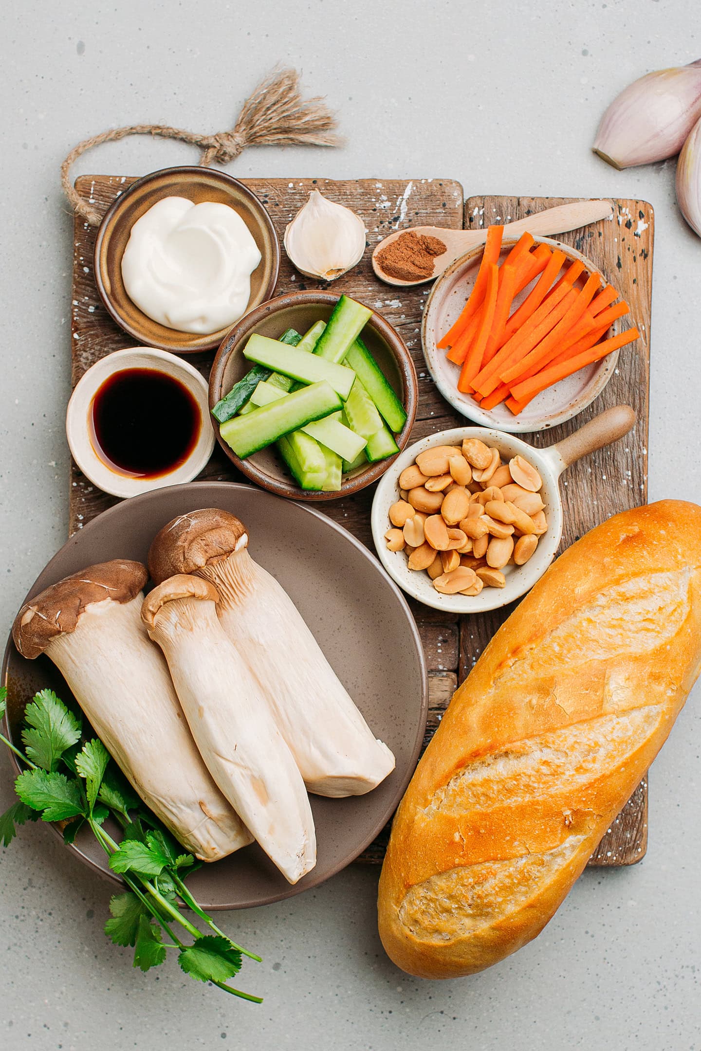 Ingredients like king oyster mushrooms, Vietnamese baguette, peanuts, carrots, and cucumber.