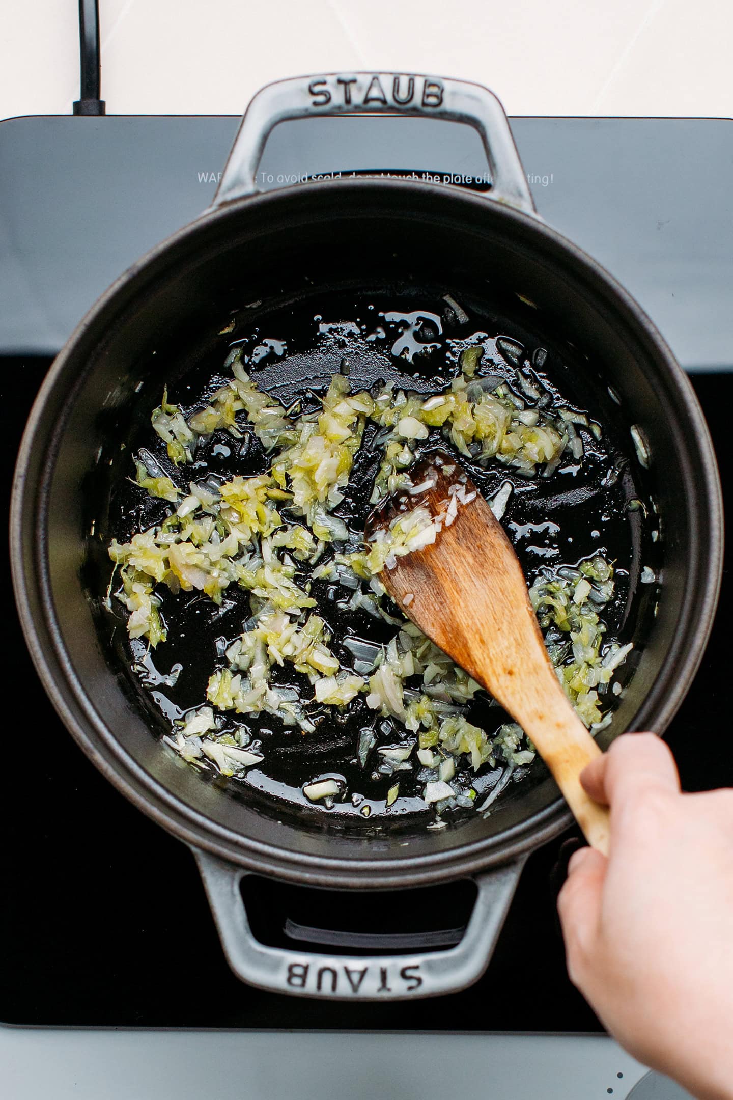 Sautéed shallots, garlic, and ginger in a pot.