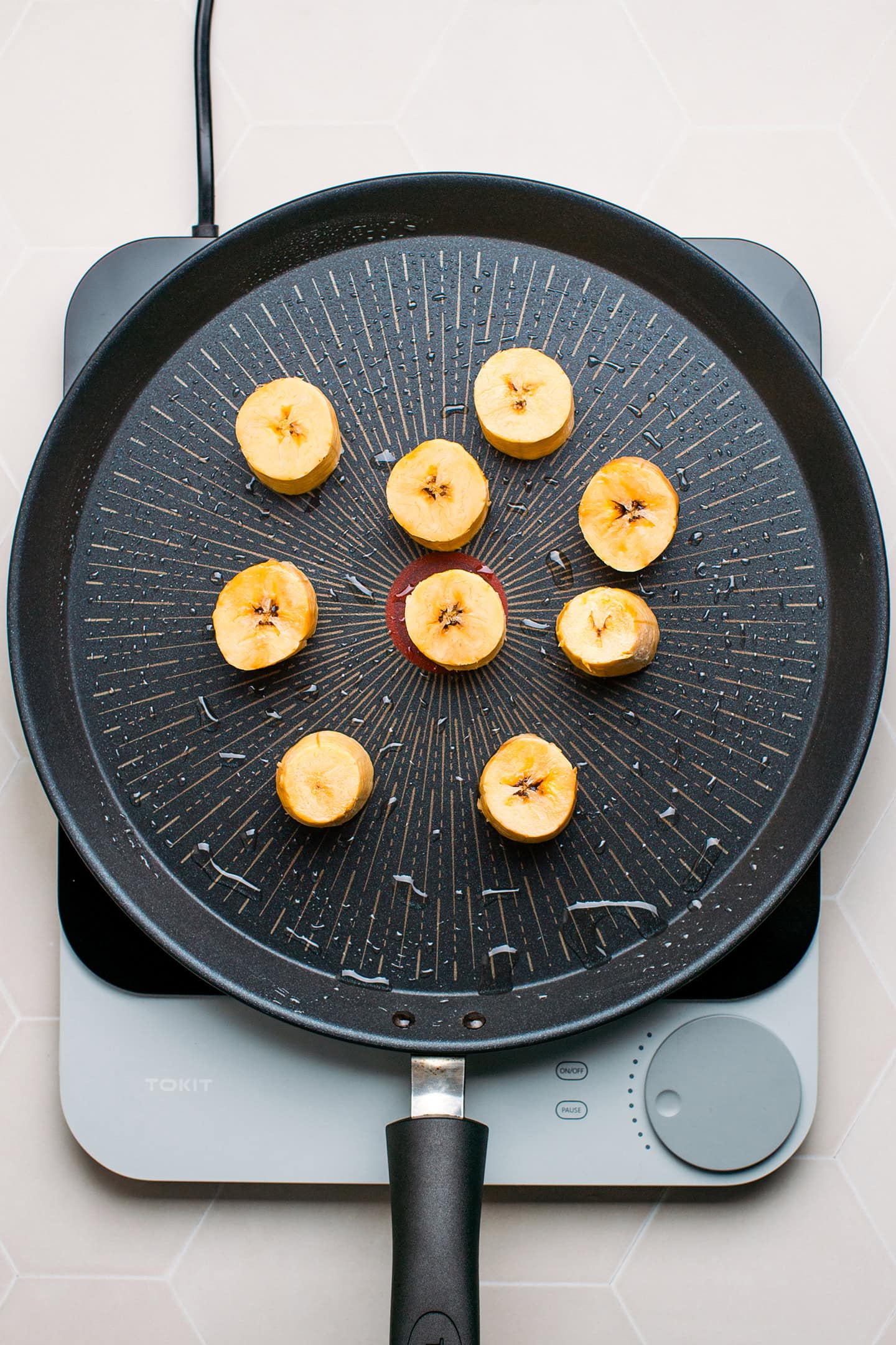 Sliced plantains in a non-stick skillet.