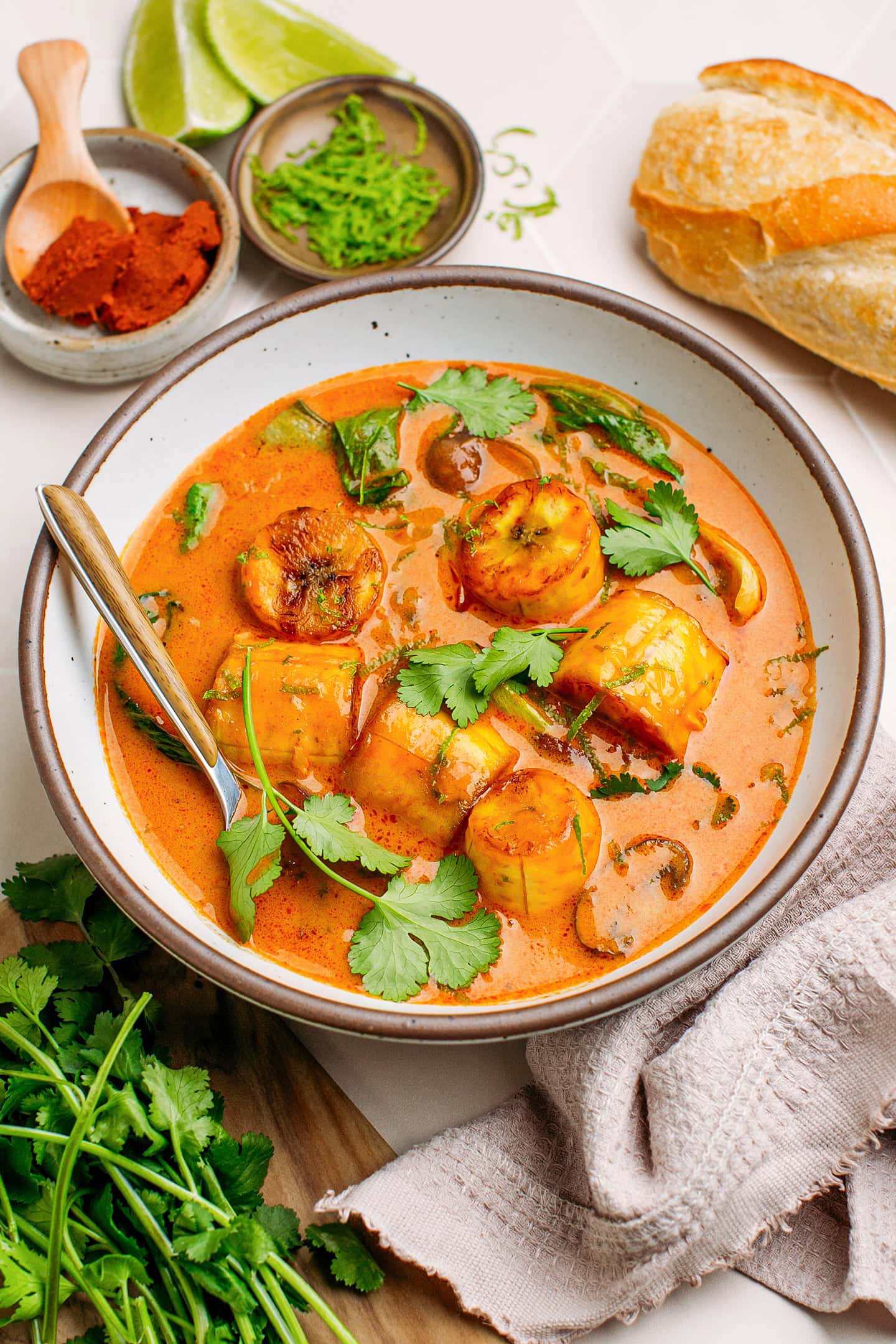 Bowl containing plantain red curry garnished with cilantro and lime zest.