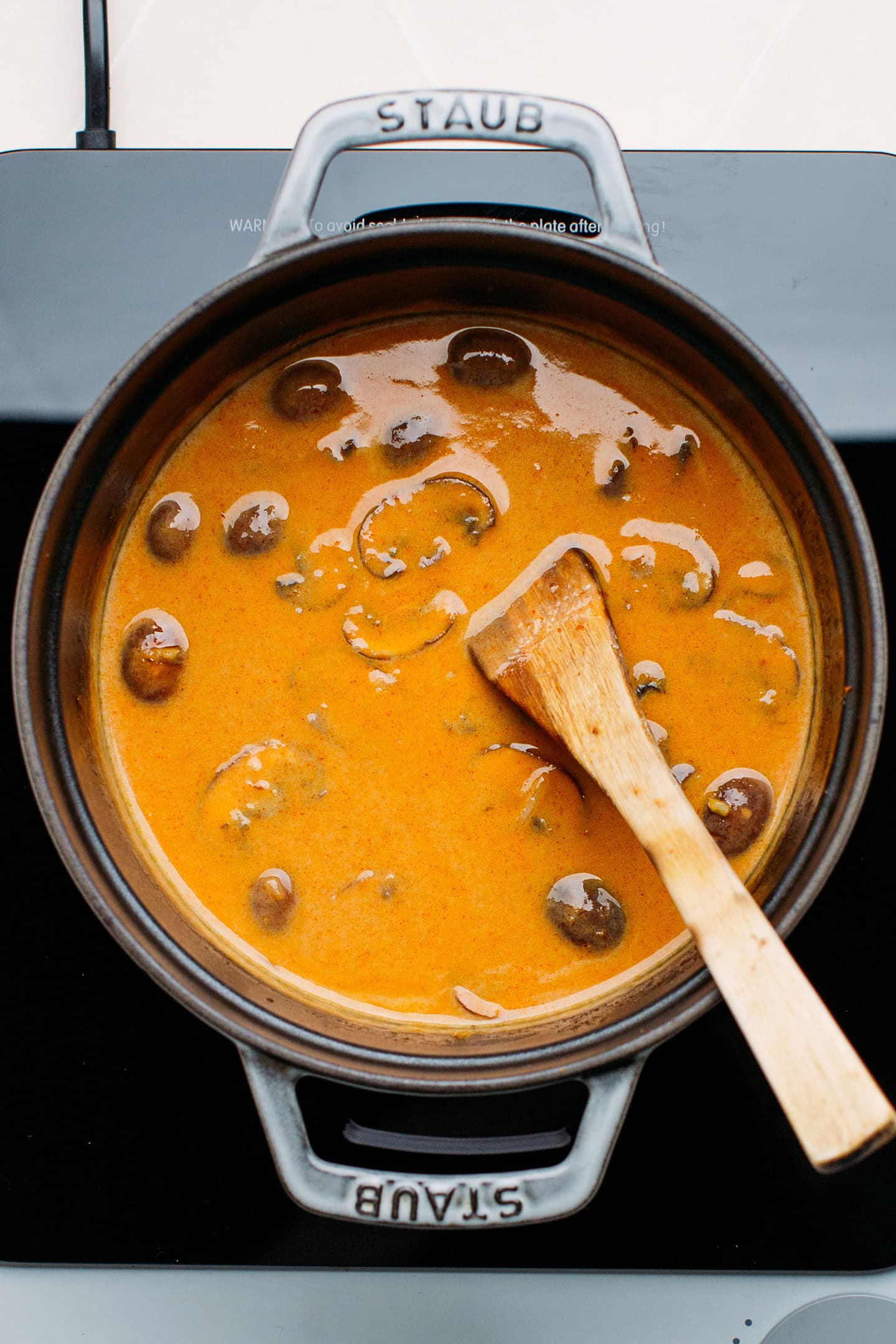 Red curry with mushroom in a pot.