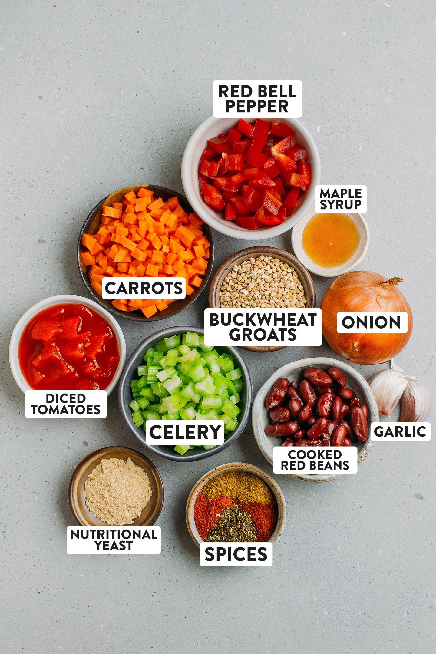 Ingredients like buckwheat groats, cooked red beans, celery, carrots, diced tomatoes, and spices.