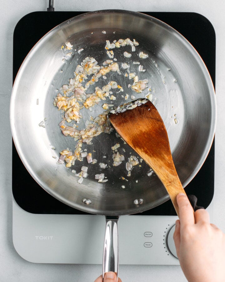 Cooking minced shallots and garlic in a skillet.