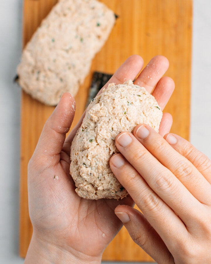 Shaping a rectangle of tofu mixture between hands.