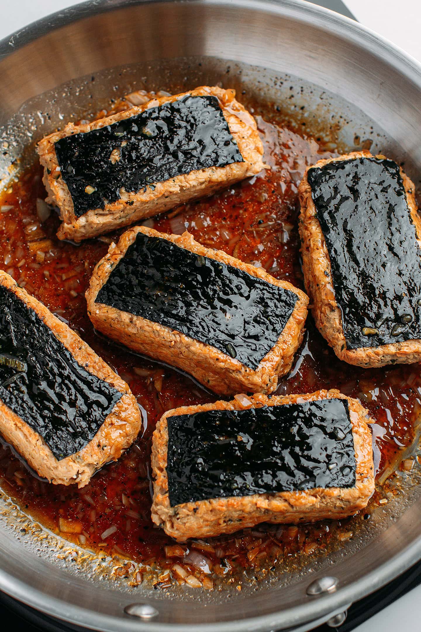 Five vegan fish fillets in a black pepper sauce.