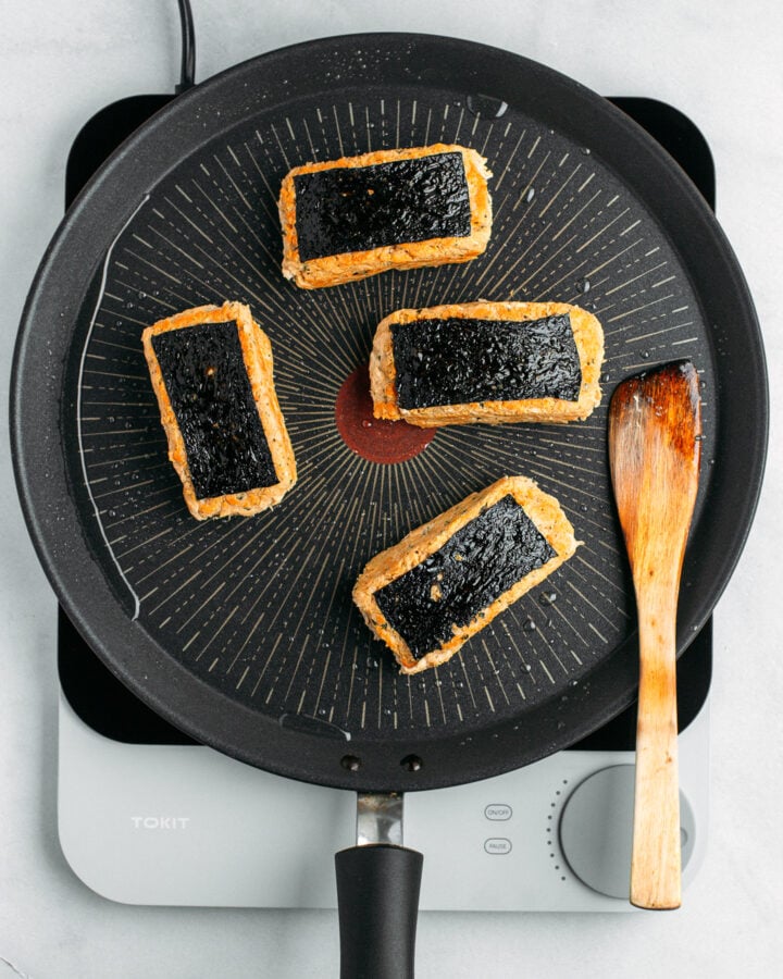 Four pieces of vegan fish on a non-stick pan.
