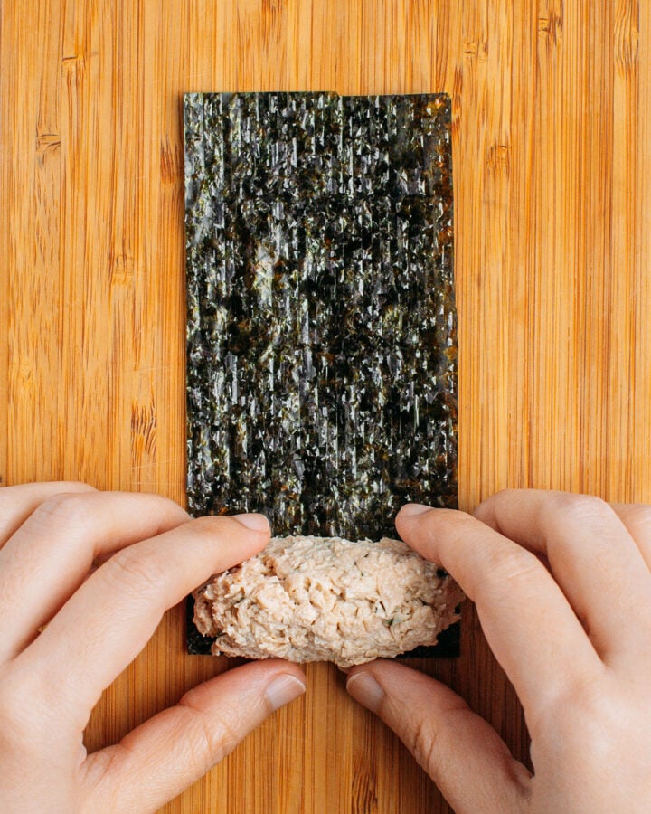 Placing tofu mixture on a sheet of nori.
