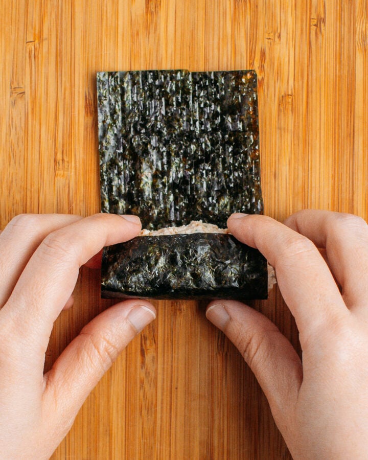 Rolling tofu mixture in a sheet of nori.