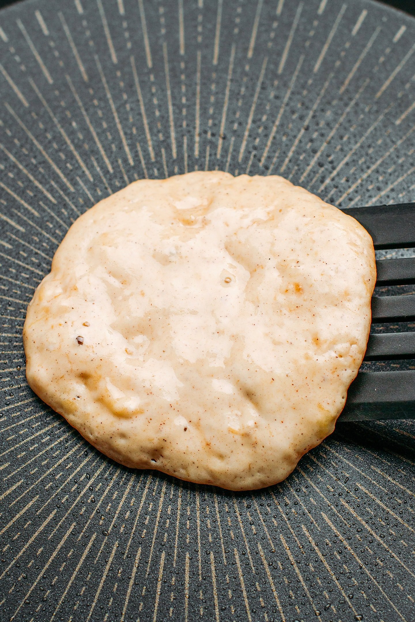 Flipping a banana pancake on a skillet.