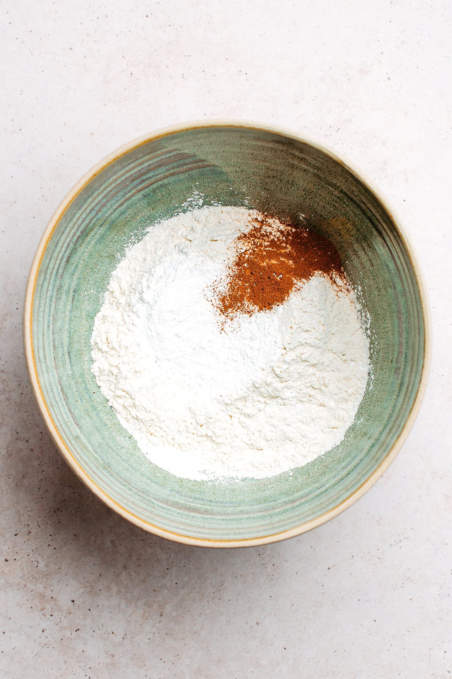 Flour, sugar, cinnamon, and baking powder in a mixing bowl.