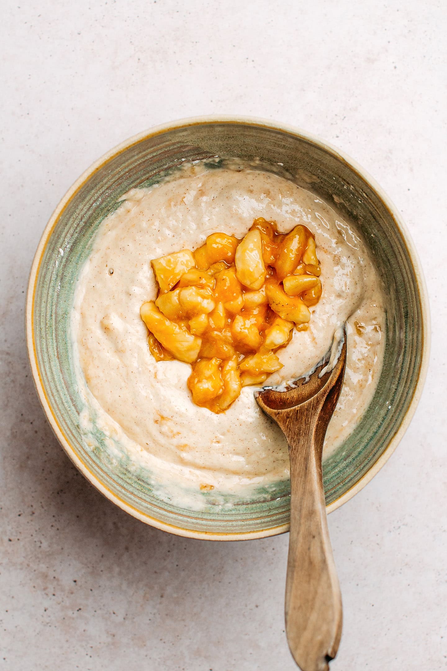 Pancake batter and diced caramelized bananas in a mixing bowl.