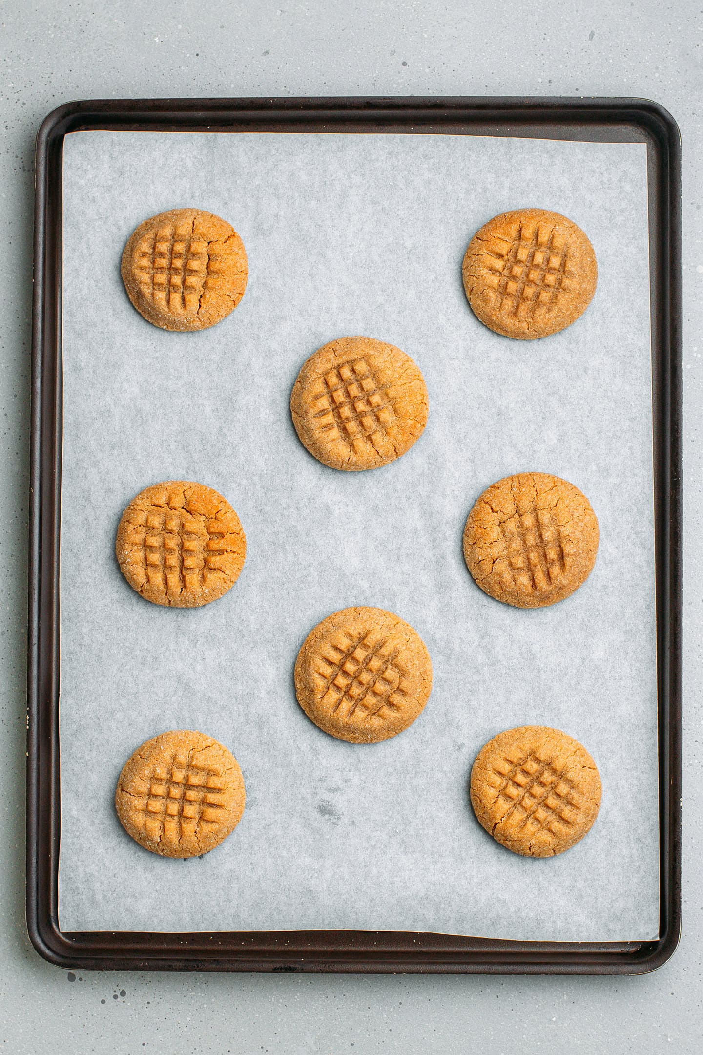 Baked peanut butter cookies on a baking sheet.