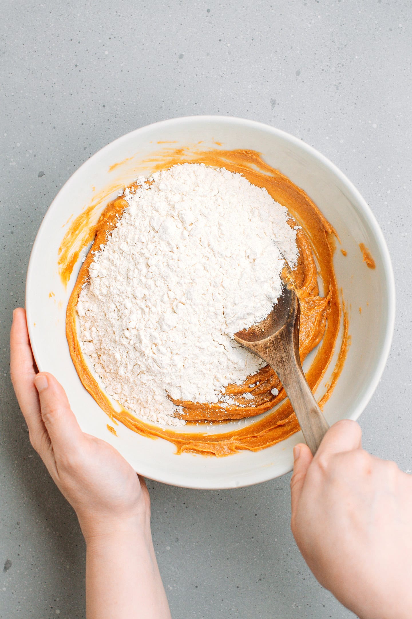 Mixing peanut butter, butter, and flour in a bowl.