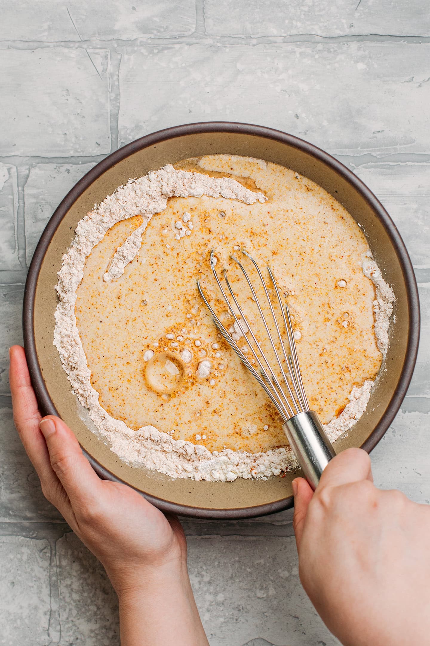 Mixing flour and curry powder with soda water.