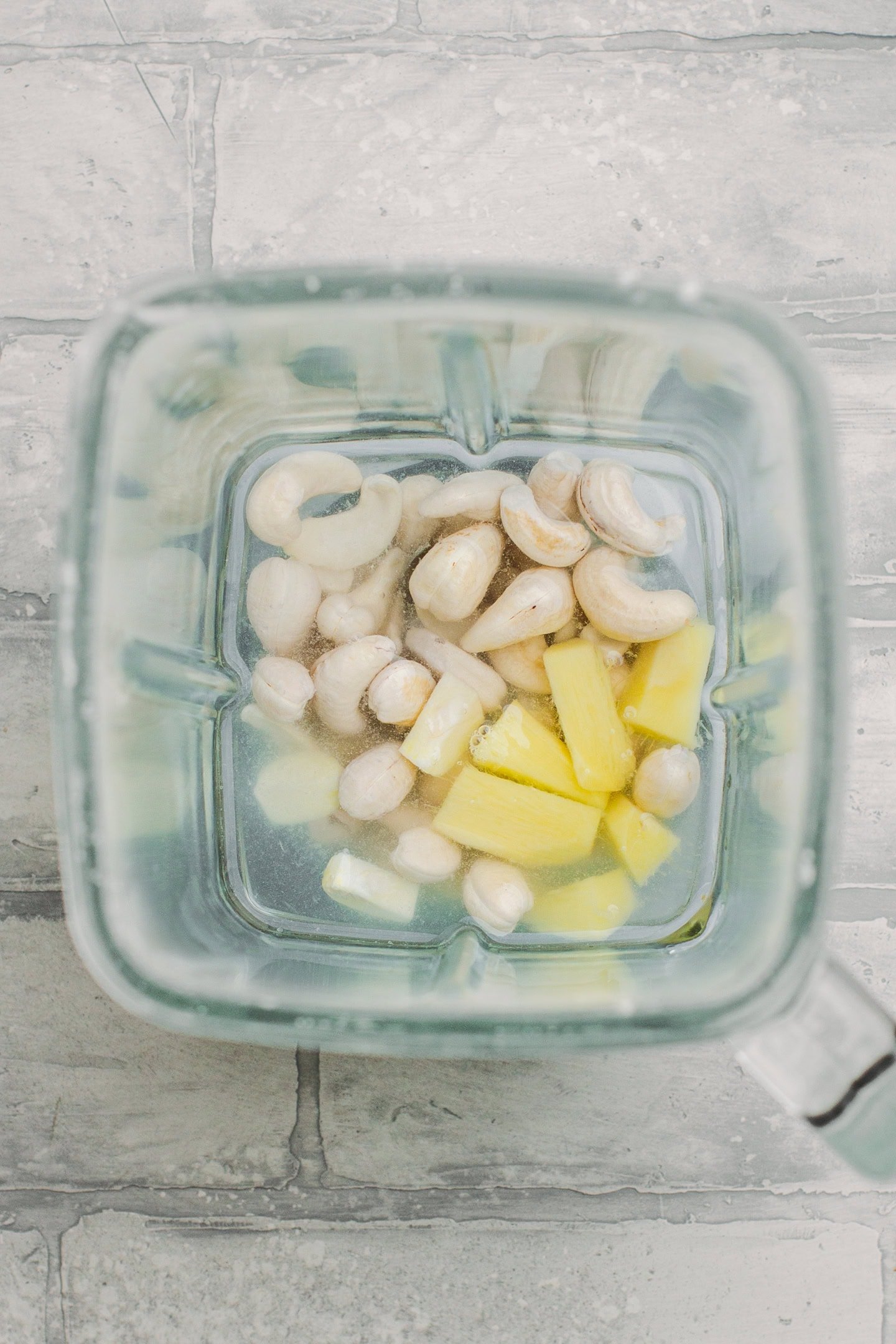 Raw cashews, ginger, and garlic in a blender.