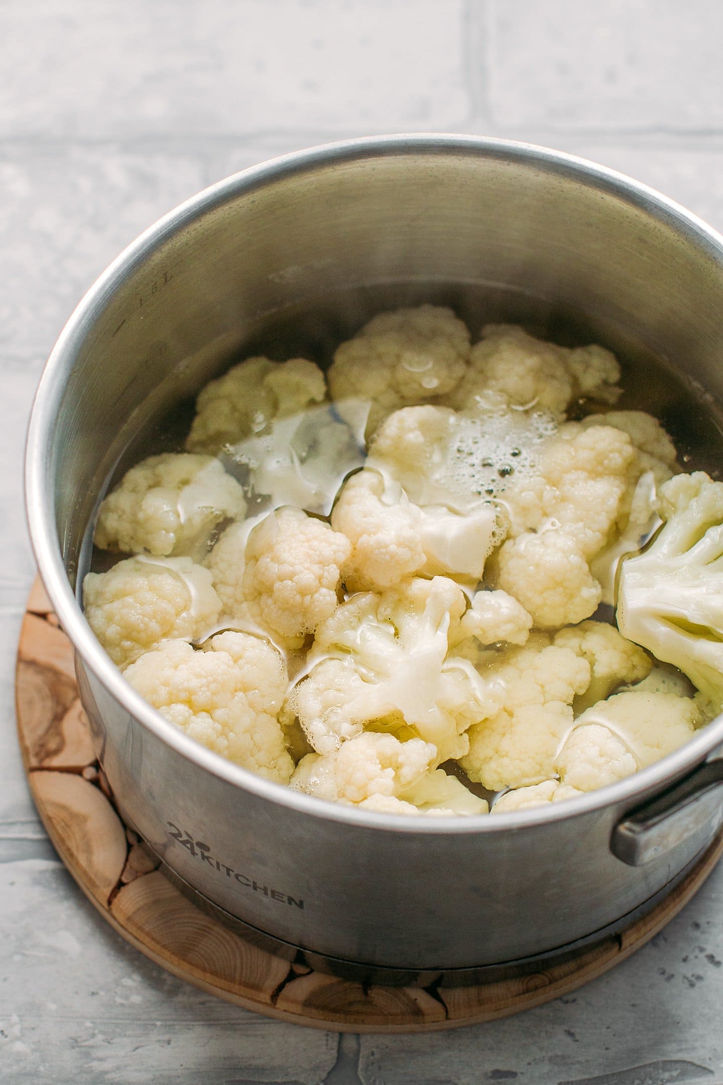 Cauliflower florets in a pot of boiling water.