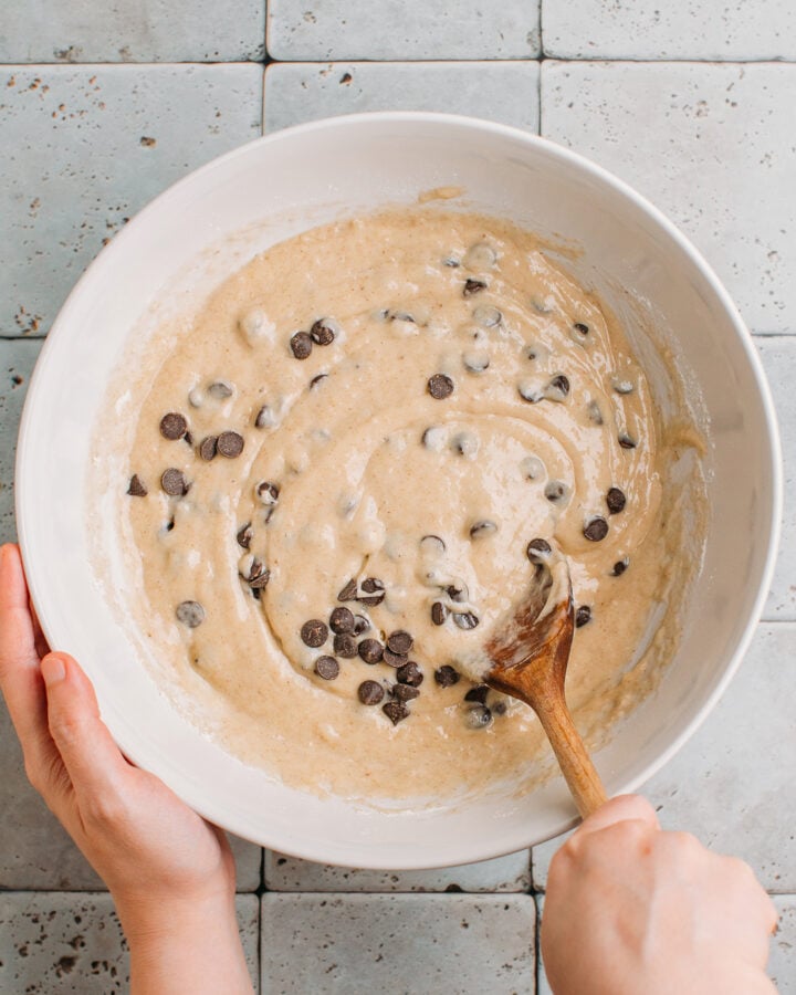 Incorporating chocolate chips into a batter.