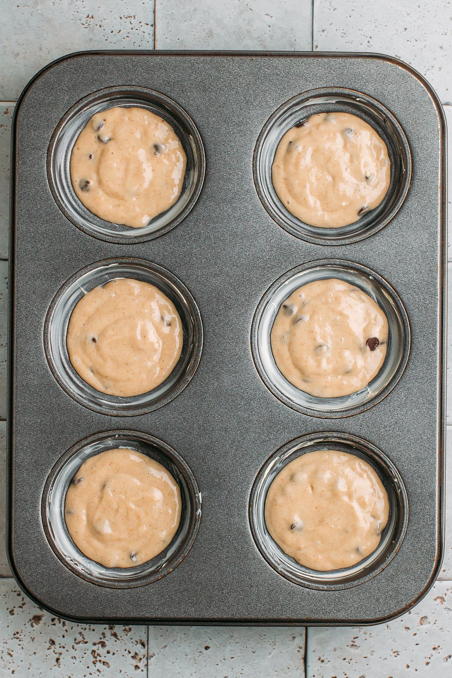 Muffin pan filled with banana batter.