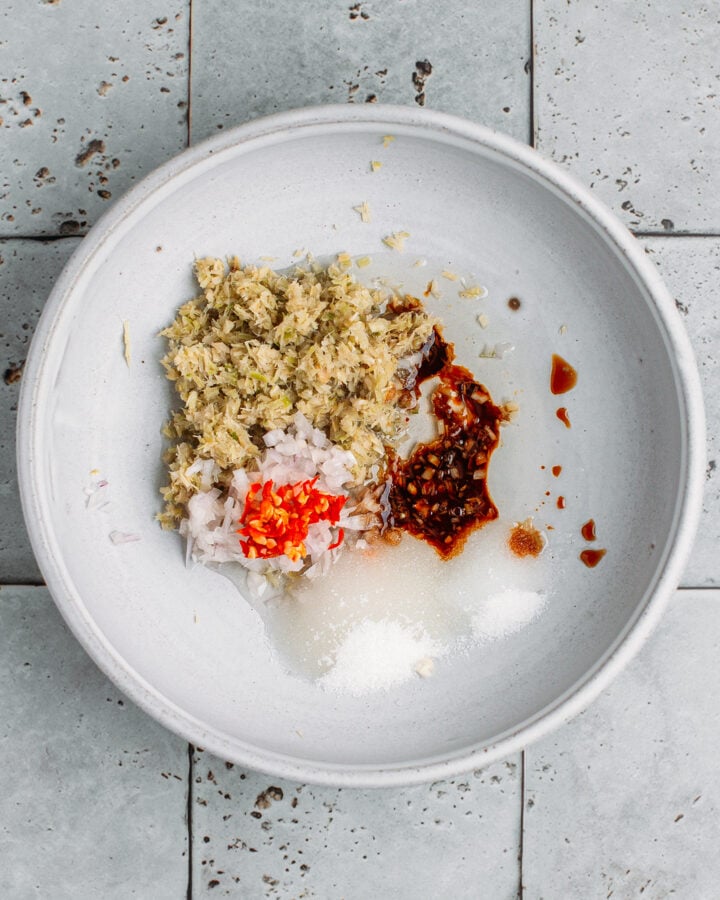 Minced lemongrass, salt, sugar, shallot, and soy sauce in a bowl.