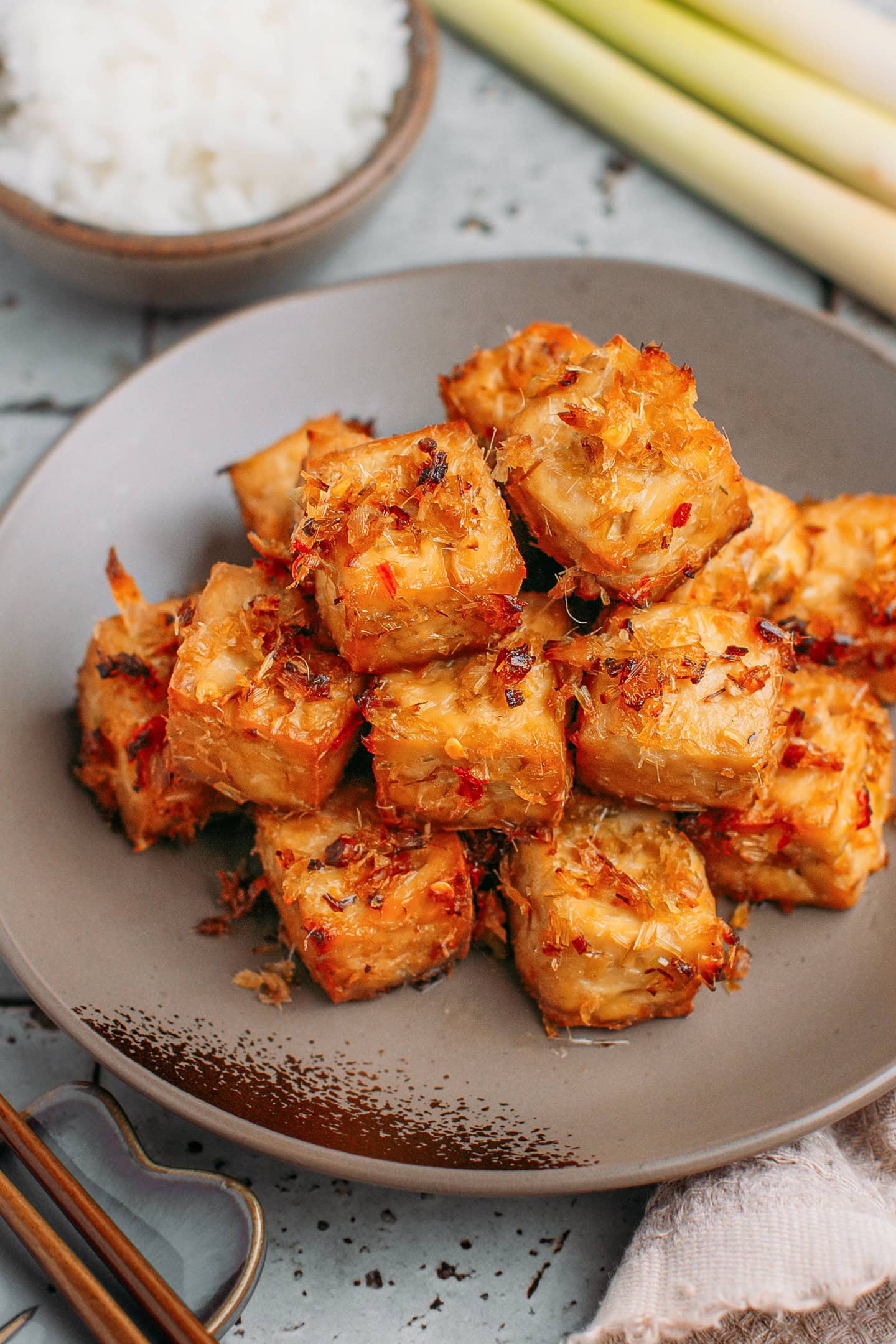 Diced tofu coated with chopped lemongrass and chili on a plate.
