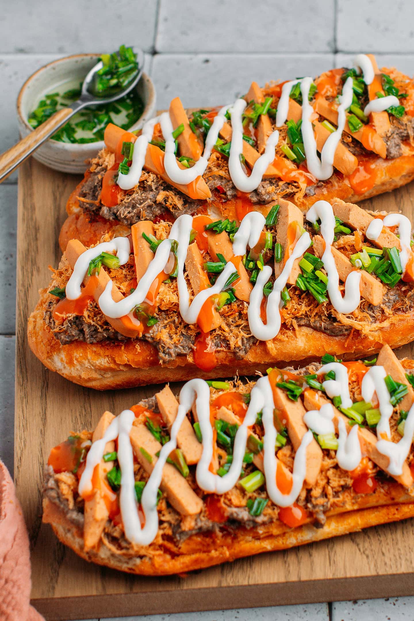 Vietnamese bread garnished with pâté, vegan meat floss, sausages, chili sauce, and mayo.