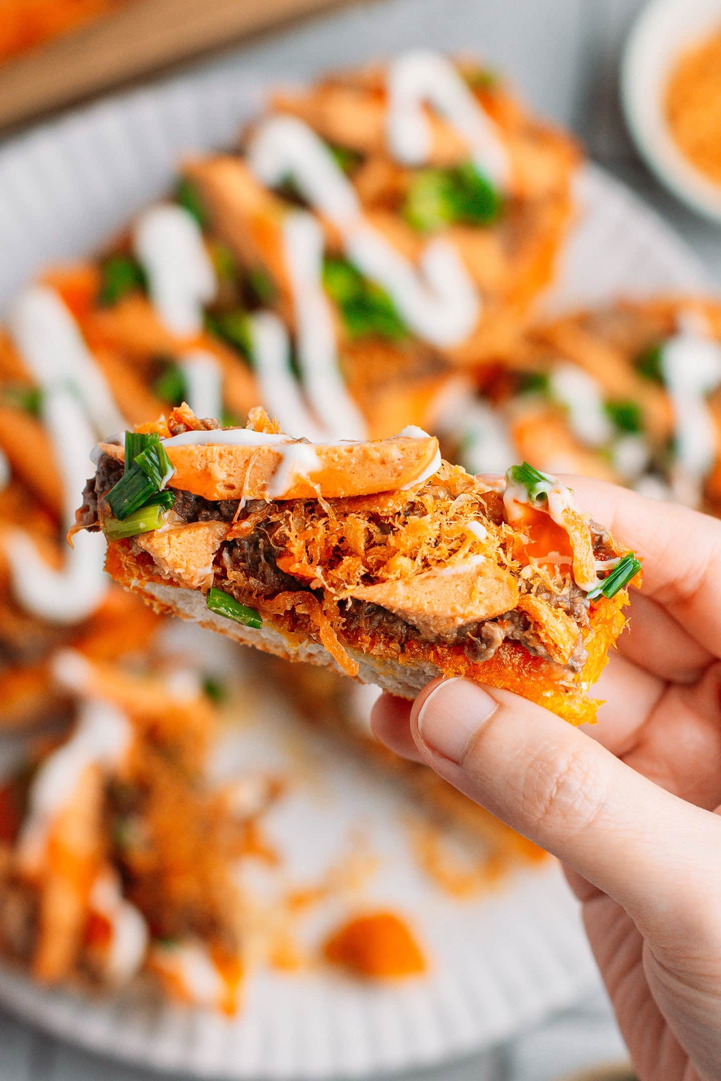 Close-up of a piece of bread topped with pâté, sausages, and mayo.