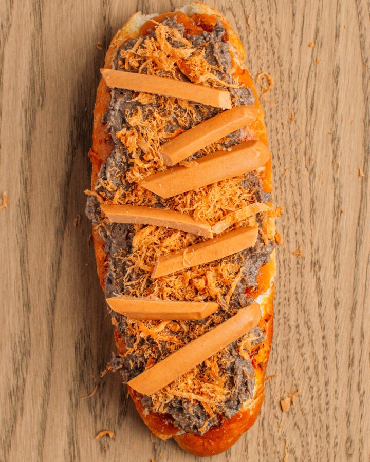 Banh mi bread topped with vegan pâté, sausages, and vegan meat floss.