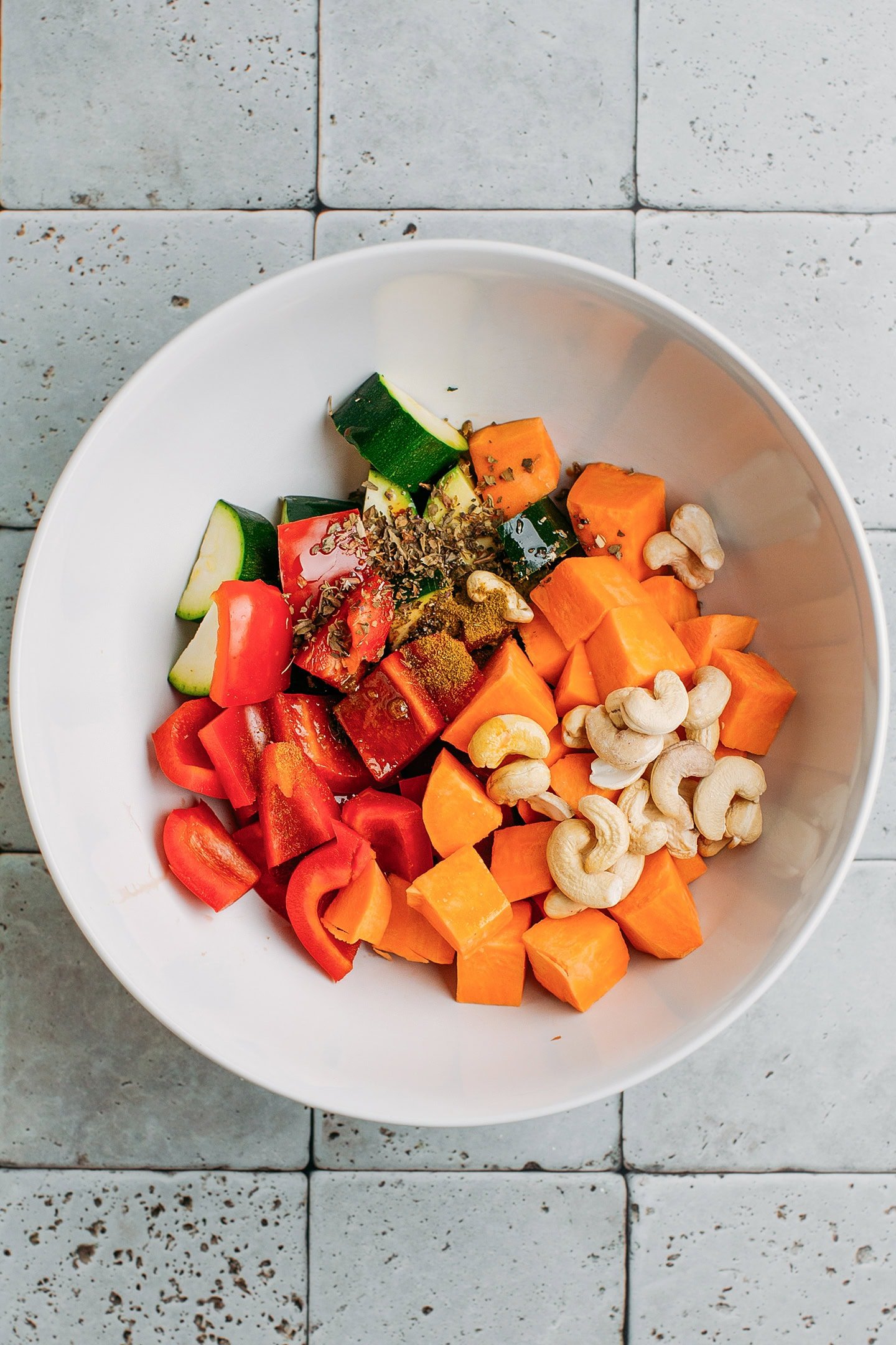 Diced sweet potato, red bell pepper, and zucchini in a mixing bowl.
