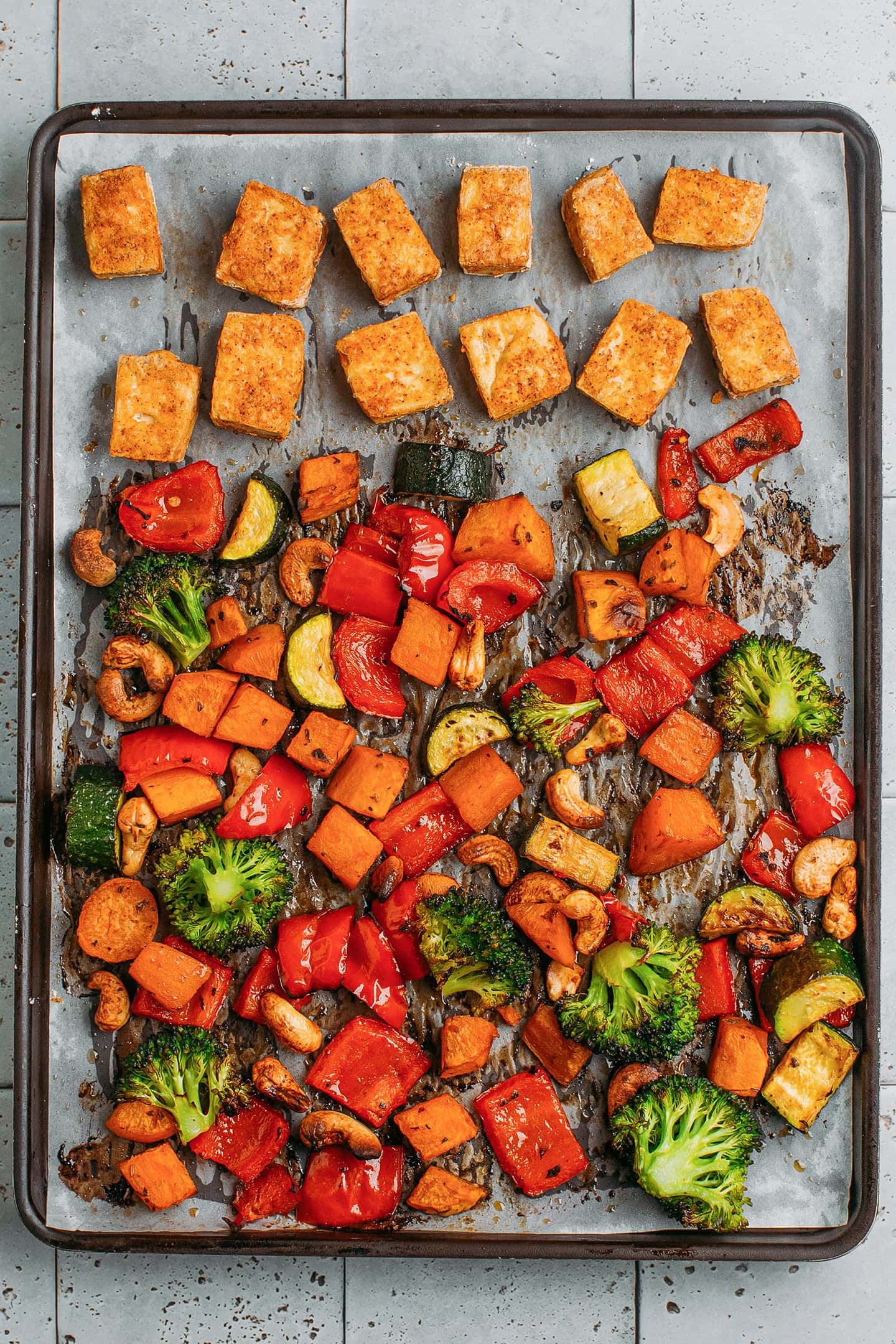 Roasted vegetables and tofu on a baking sheet.