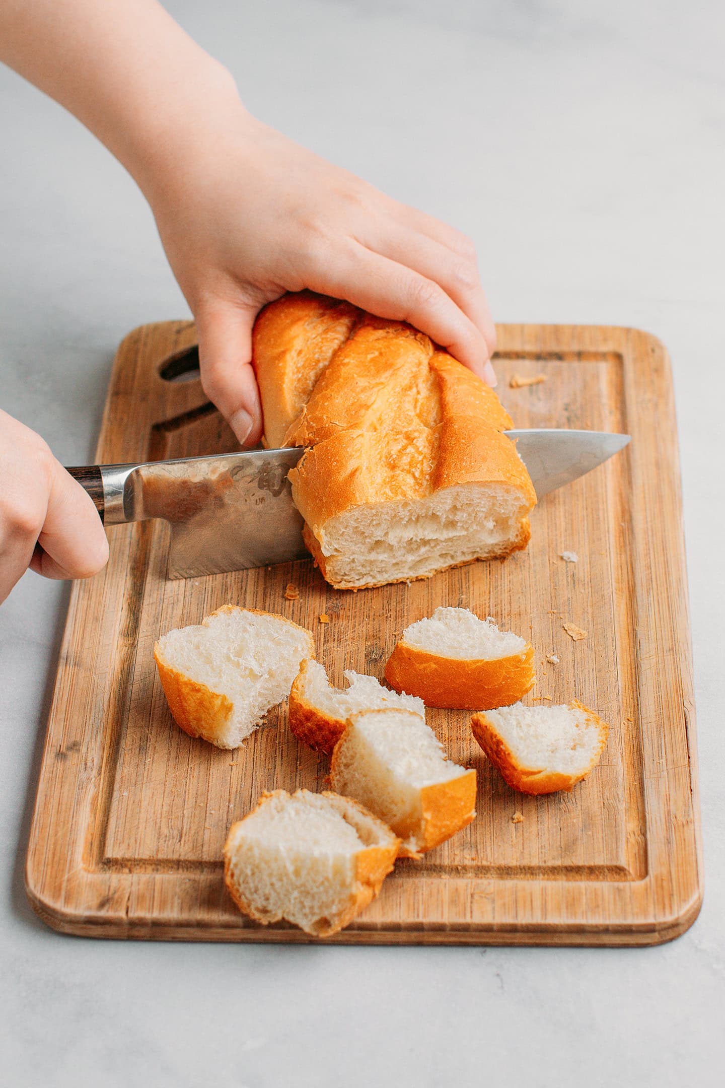 Slicing a loaf of bread into cubes.