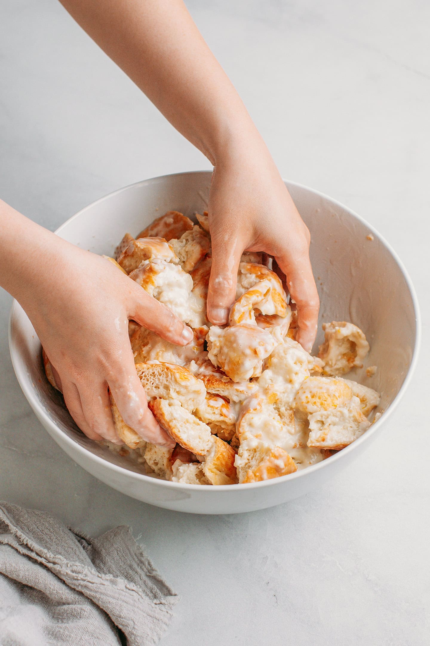 Tossing diced bread with coconut milk.