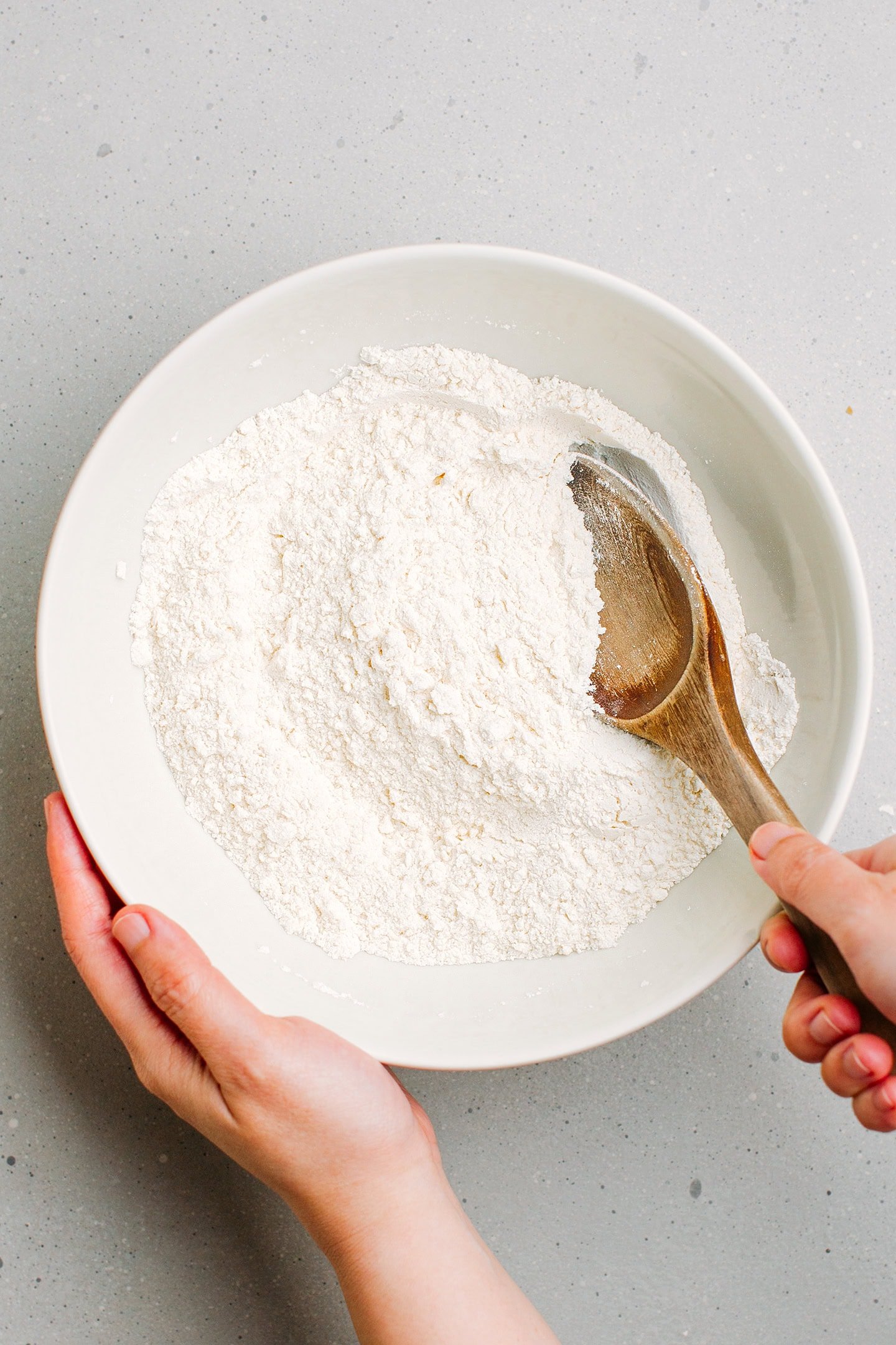 Mixing flour and sugar in a mixing bowl.