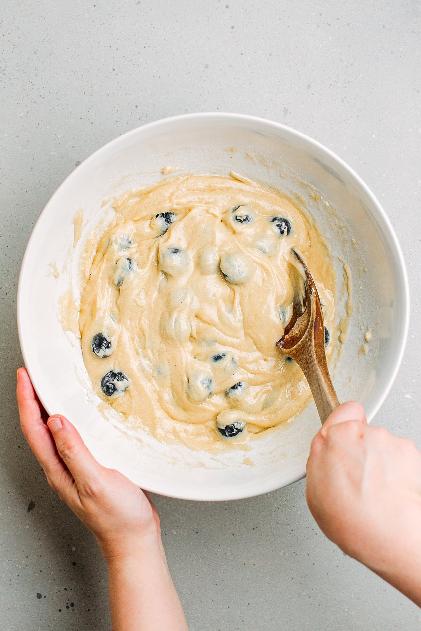 Incorporating blueberries into a batter.