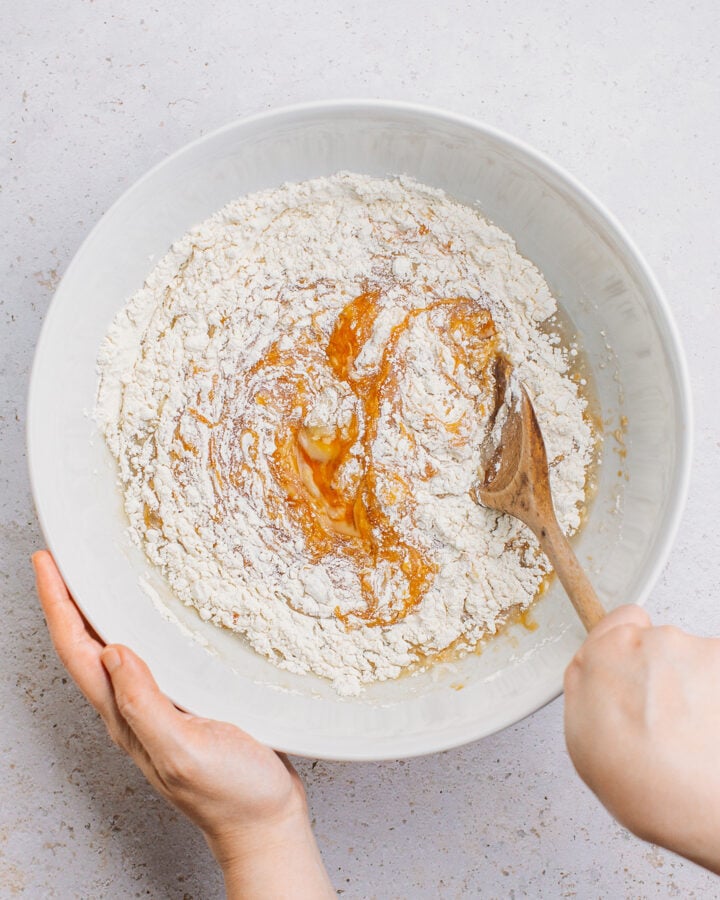 Mixing caramel sauce and flour in a large bowl.