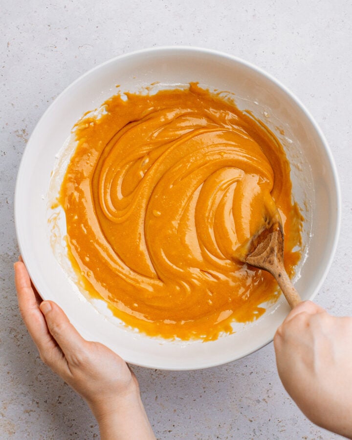 Sitrring caramel cake batter in a large mixing bowl.