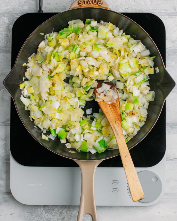 Sautéed chopped leeks in a skillet.