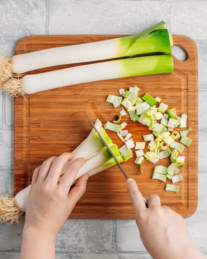 Slicing leeks on a cutting board.