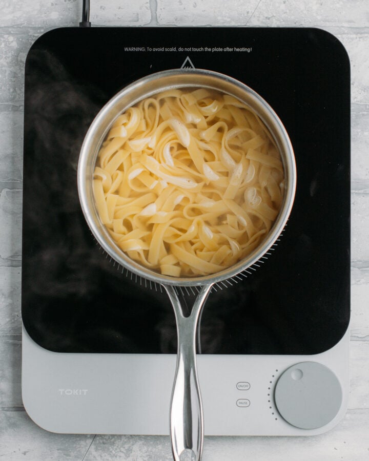 Cooking tagliatelle pasta in a pot of water.
