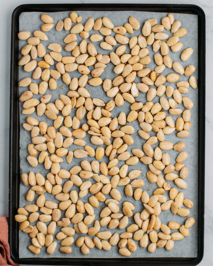Blanched almonds on a baking sheet before baking.
