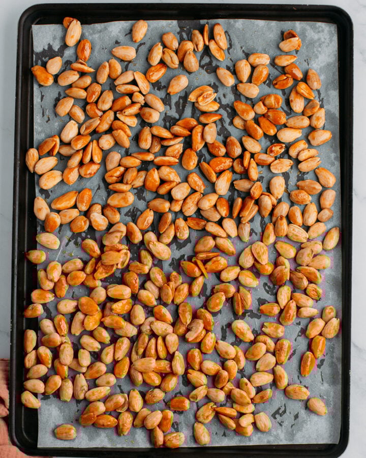 Roasted blanched almonds on a baking sheet.
