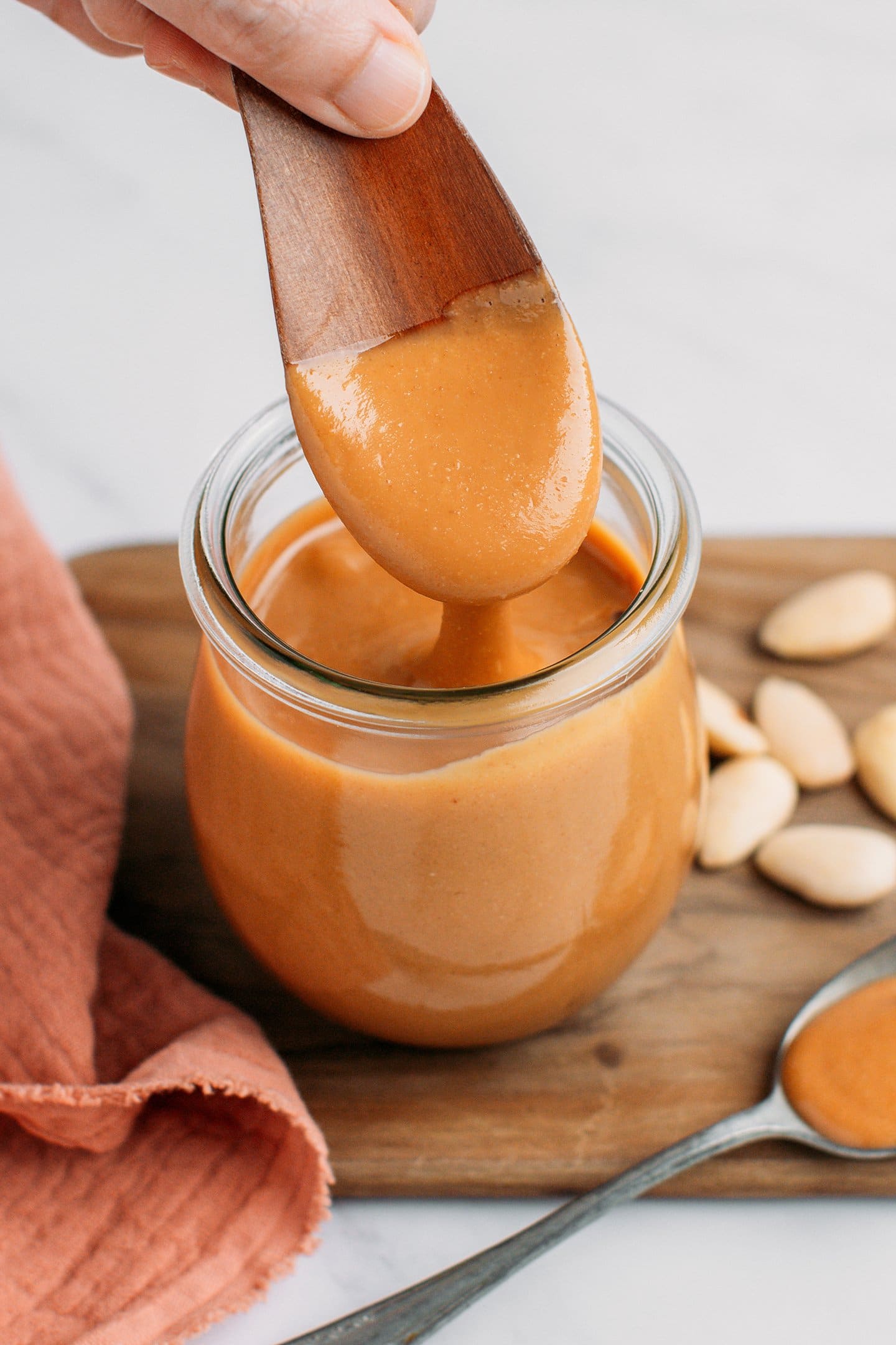 Dipping a wooden spoon into blanched almond butter.