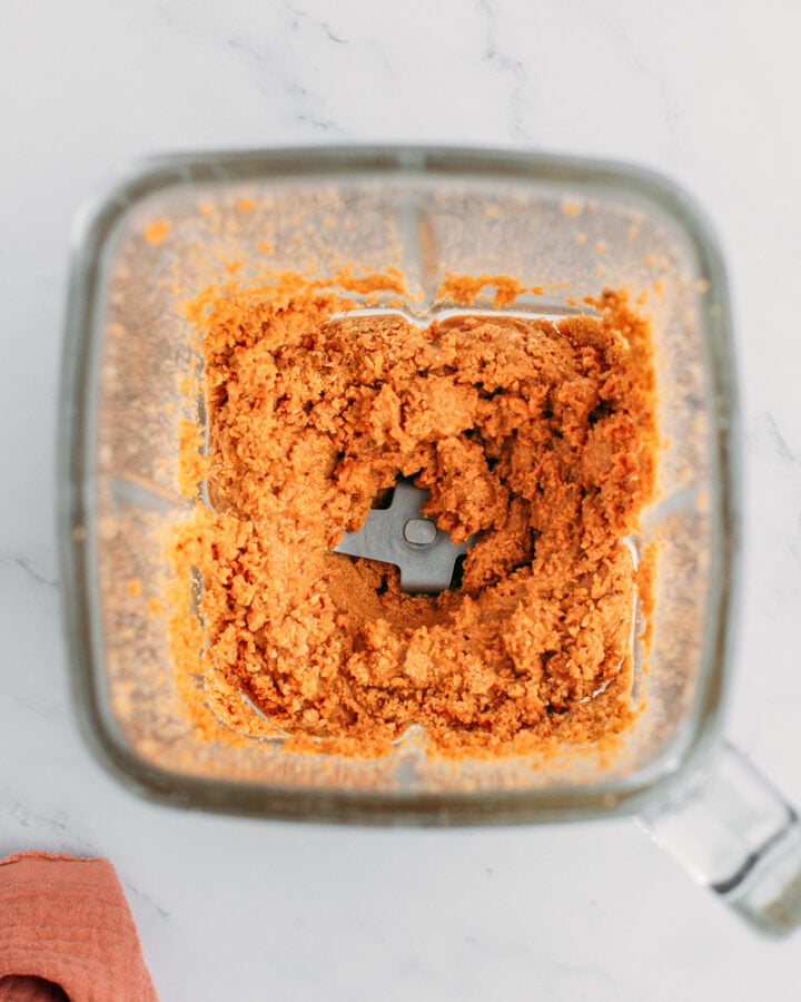 Roasted almond paste in a blender.