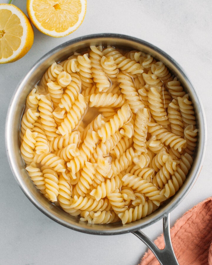 Cooked fusilli pasta in a pot of water.