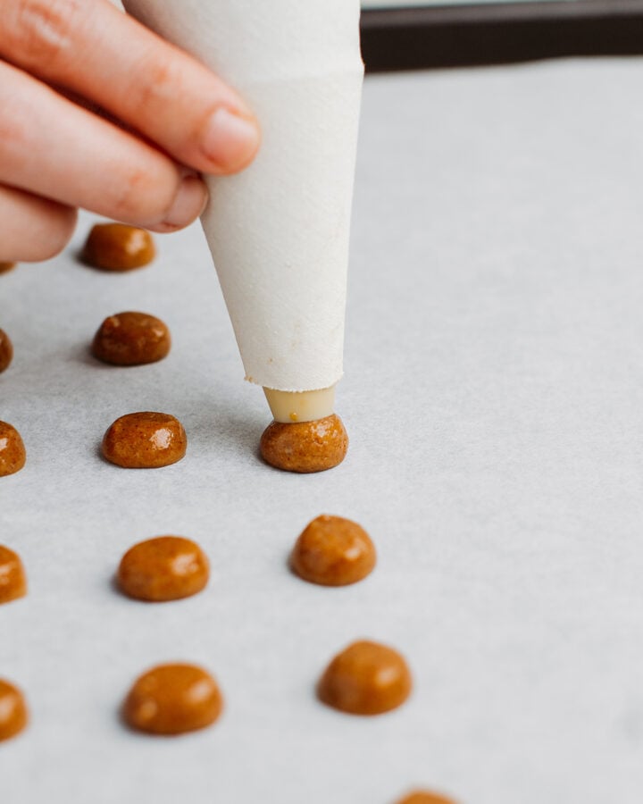 Piping cereal batter on a baking sheet.