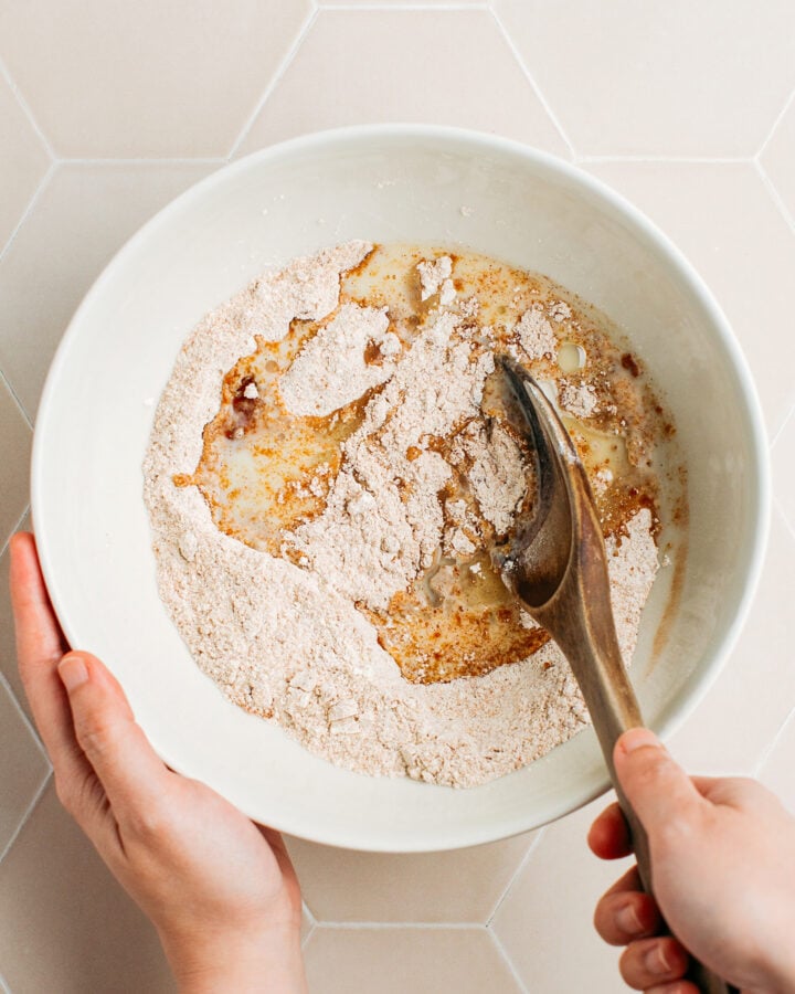 Mixing flour, brown sugar, cinnamon, and milk in a bowl.