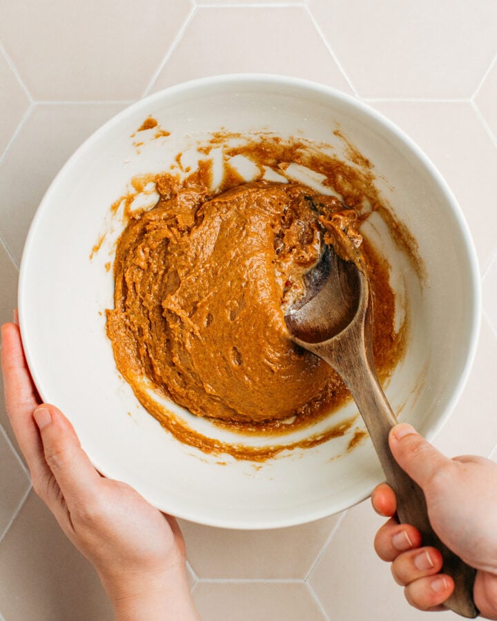 Mixing cinnamon cereal batter in a bowl.