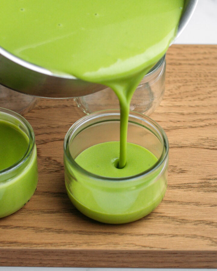 Pouring panna cotta into a glass ramekin.