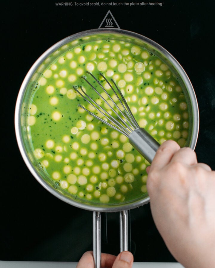 Whisking matcha, milk, cocoa butter, and cornstarch in a saucepan.